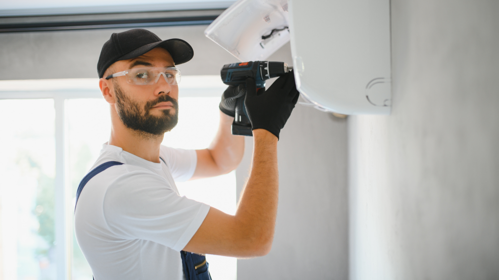 cold room manufacturers man drilling new cooling fan into cold room